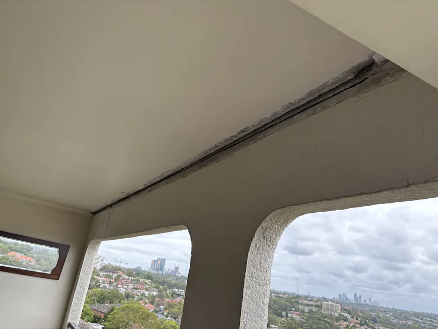Painted ceiling above a wide picture window looking over rooftops