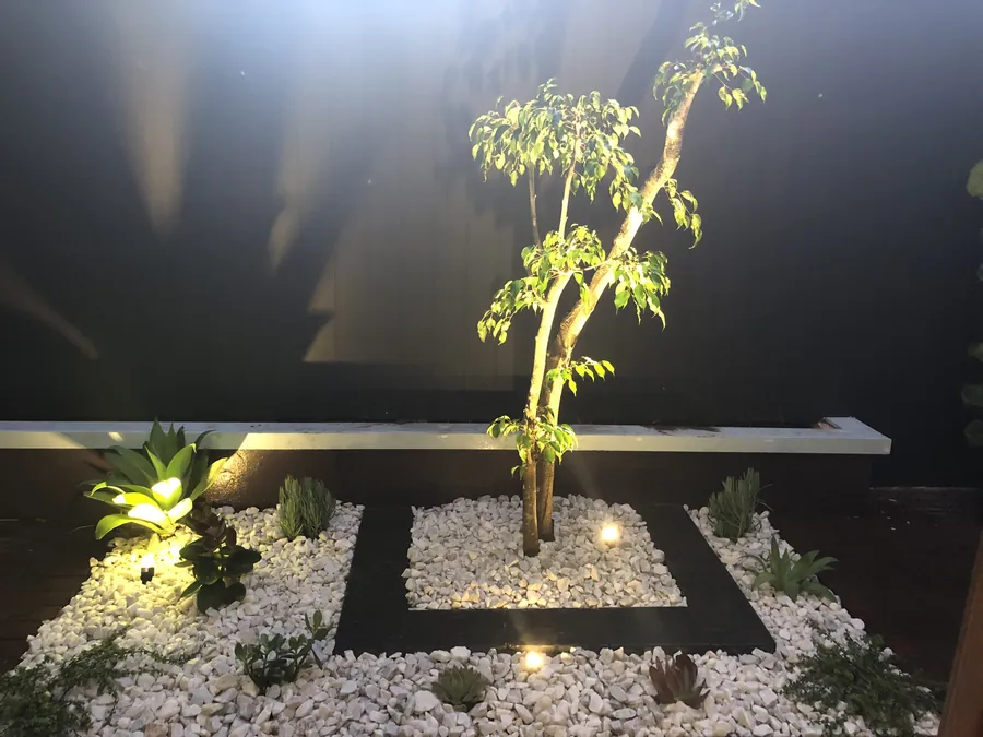 Close up of a pebble bed with planting and low garden lights