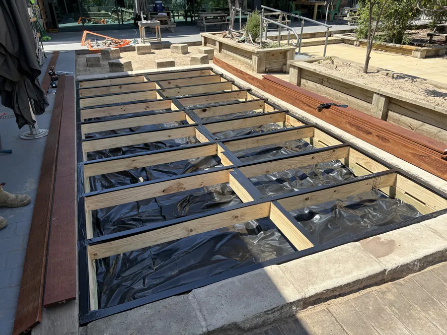 Timber deck framing with black membrane laid between the joists