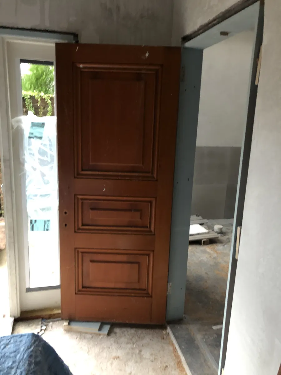 Solid timber panelled front door hung in a new opening