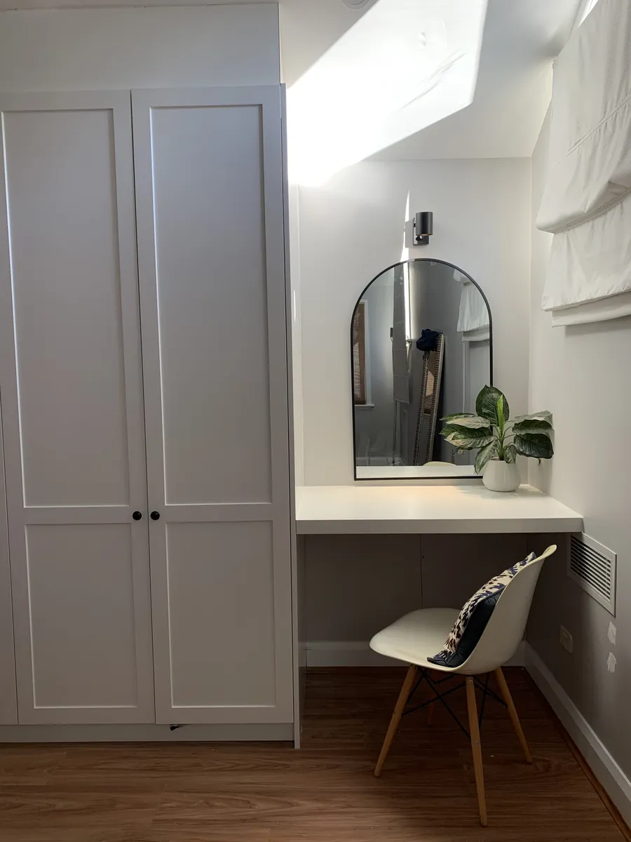 Built-in white wardrobe with a desk nook and mirror